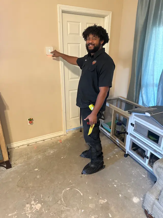Air City technician fitting a smart thermostat in a Cypress home