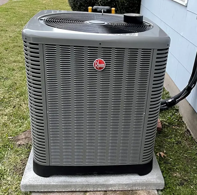 Newly installed outdoor condenser on a fresh pad beside a Cypress home